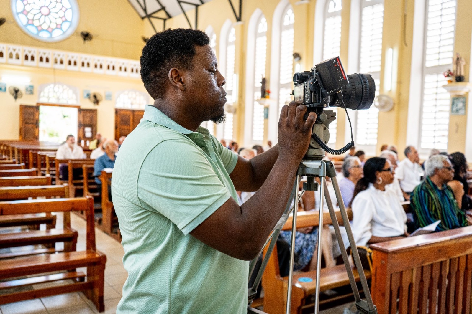 Allen filming on location with a camera and tripod