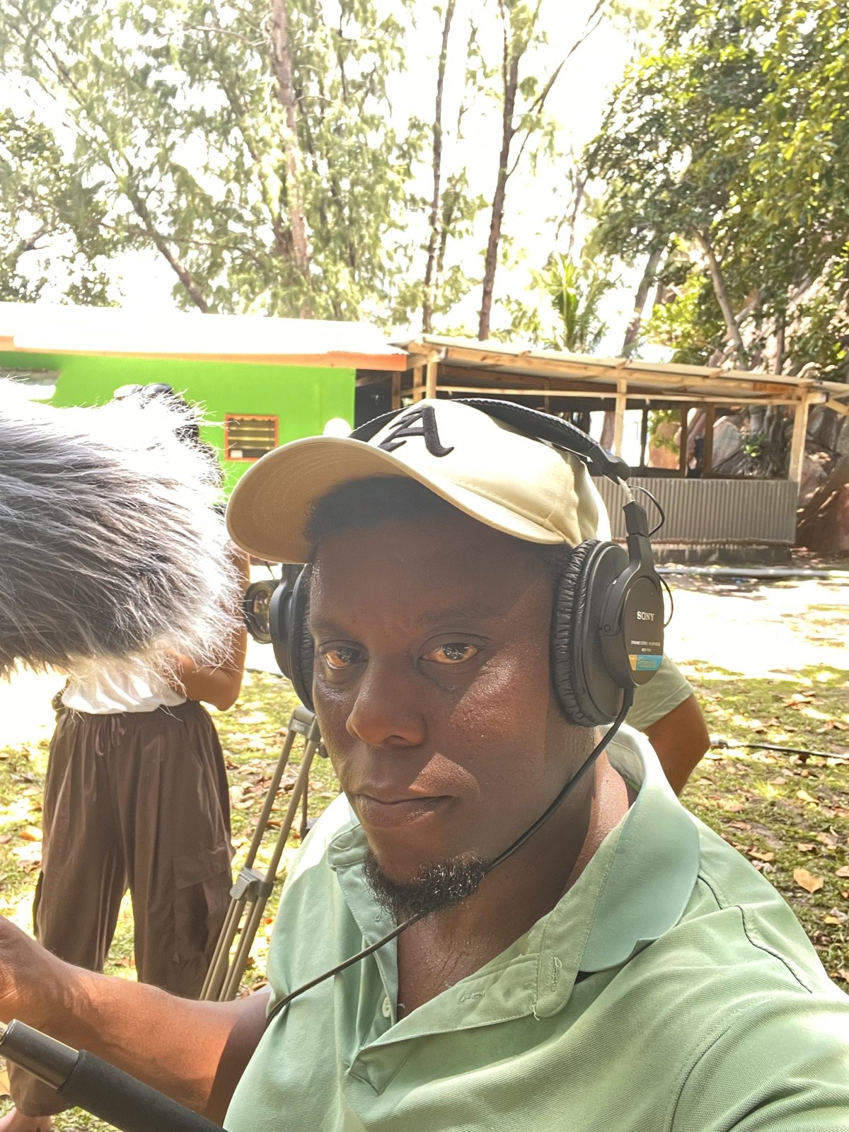 Allen wearing headphones with a microphone on location